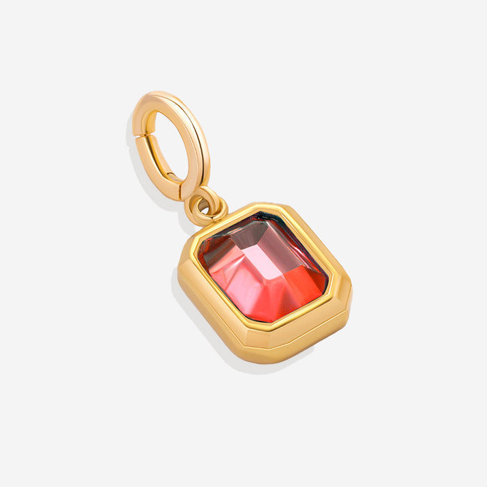 A collection of gold-colored birthstone charms with different colored gemstones, arranged in a row.
