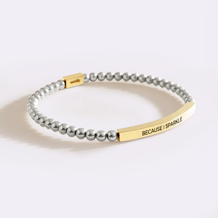 Bracelet with gray beads and gold clasp on a white background