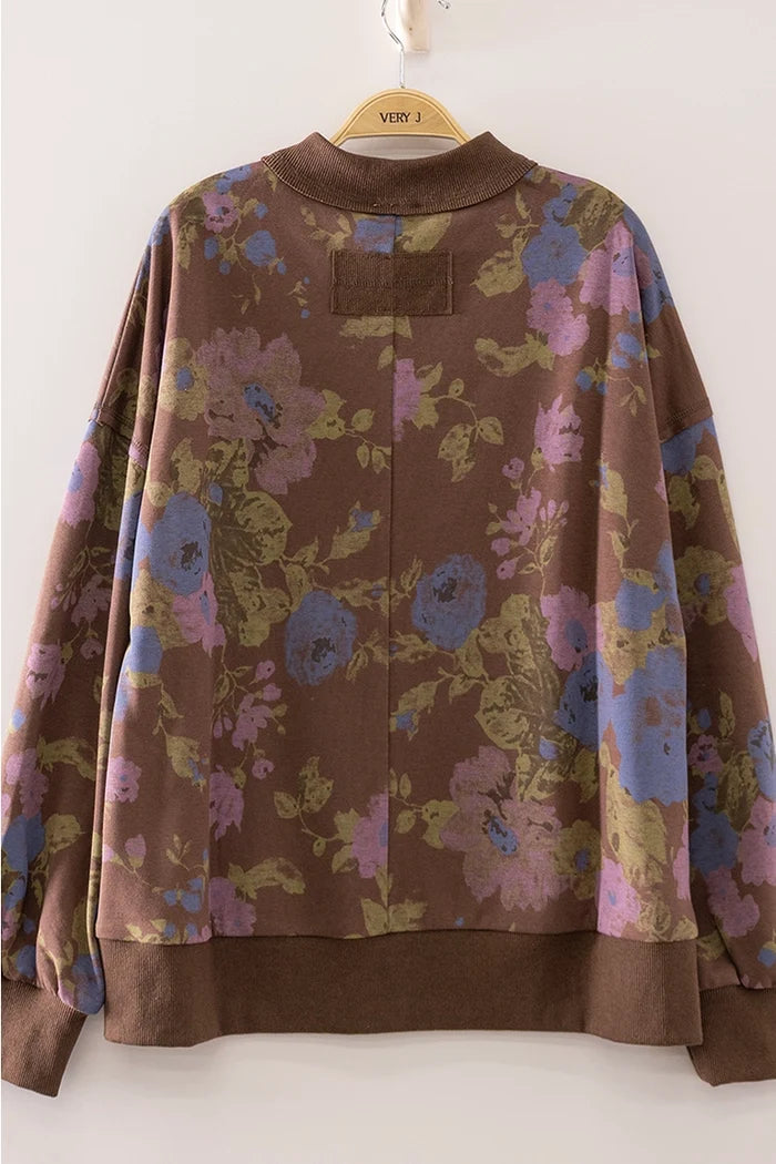Floral patterned jacket on a hanger against a white background