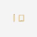 A pair of gold-colored square huggie earrings on a black background.