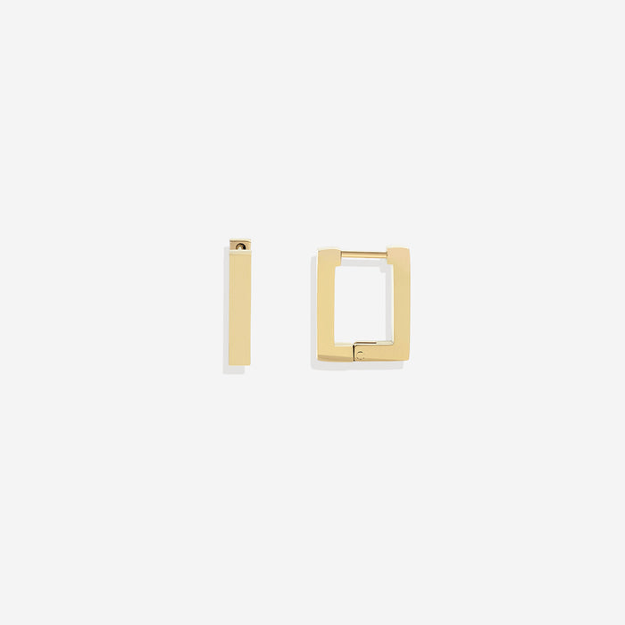A pair of gold-colored square huggie earrings on a black background.