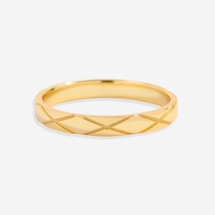 A gold ring with a textured hatched pattern, displayed against a black background.