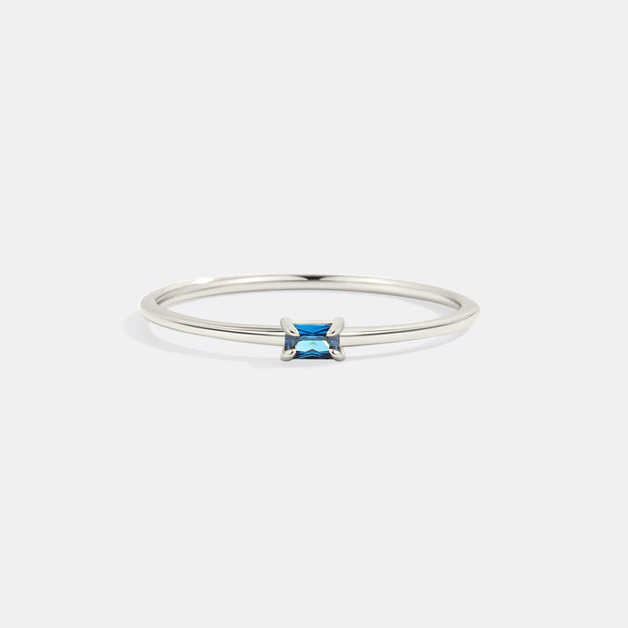 Silver ring with a blue gemstone on a white background
