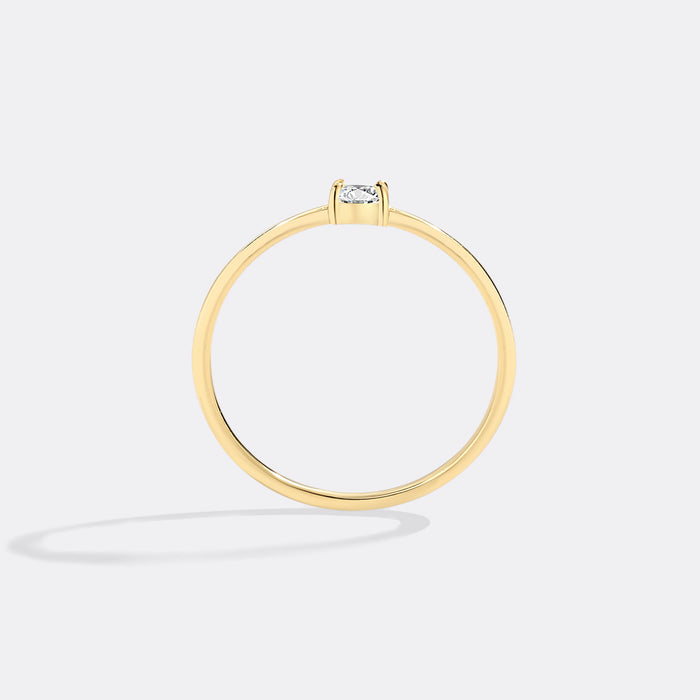 Gold ring with a diamond on a light gray background