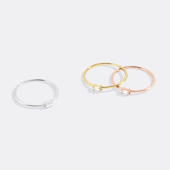 Three bangles in silver, gold, and rose gold on a white background