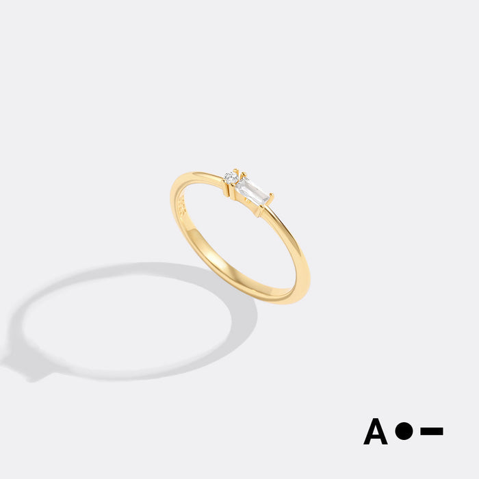 Gold ring with a diamond on a light gray background