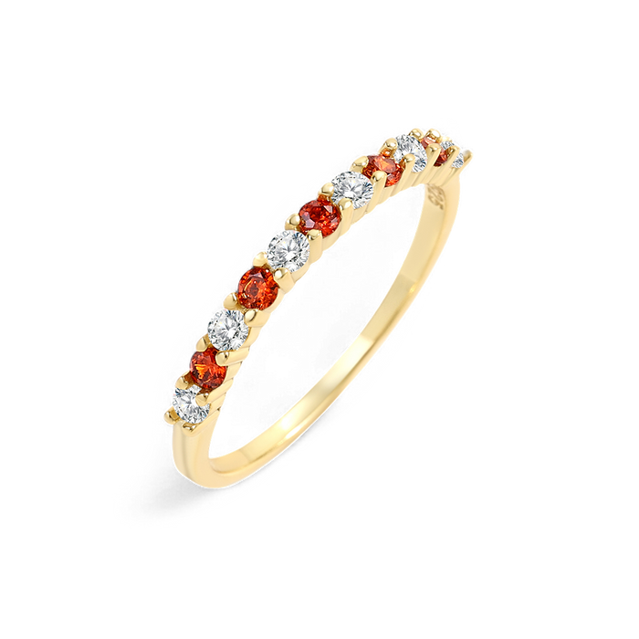 Gold ring with red and clear gemstones on a white background