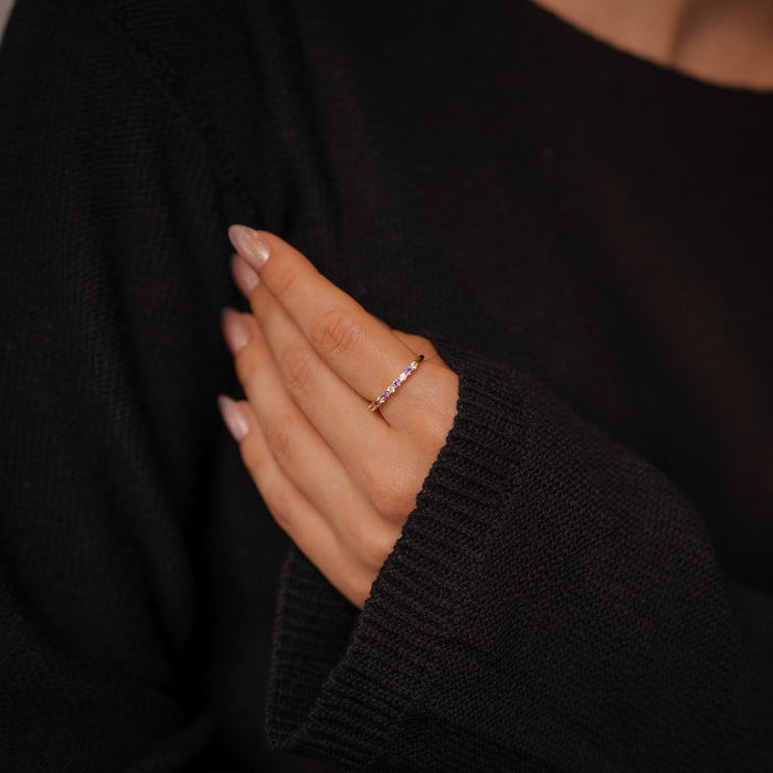 Hand wearing a ring with a black sweater background