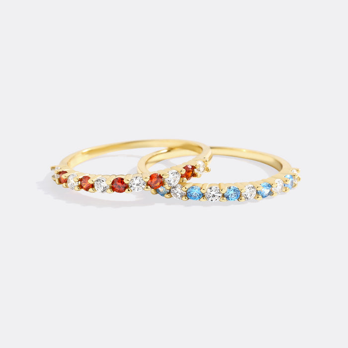 Gold ring with colorful gemstones on a white background