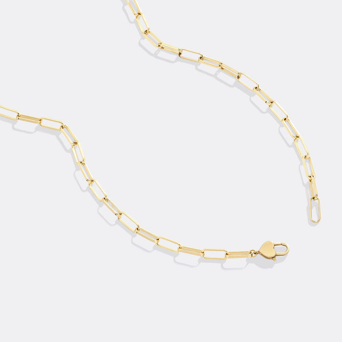 Gold chain necklace with clear beads on a white background