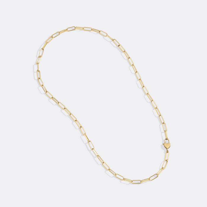 Gold chain necklace on a light gray background