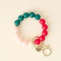 Beaded bracelet with pink, red, and green beads on a beige background