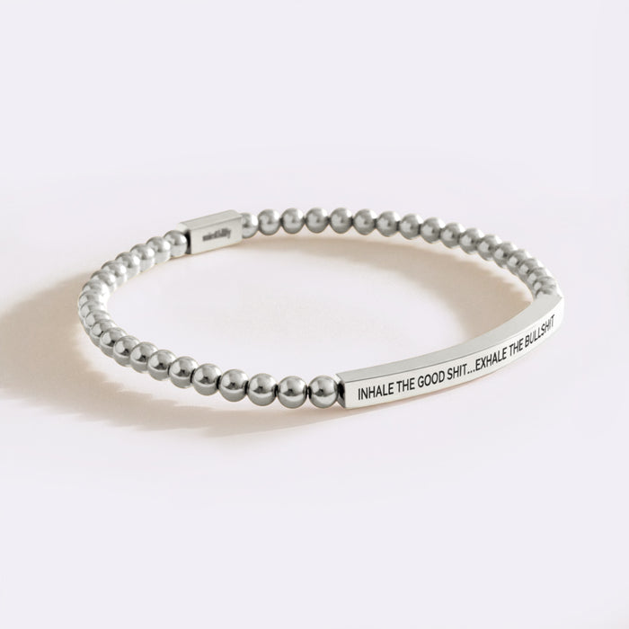 Silver beaded bracelet with engraved text on a white background