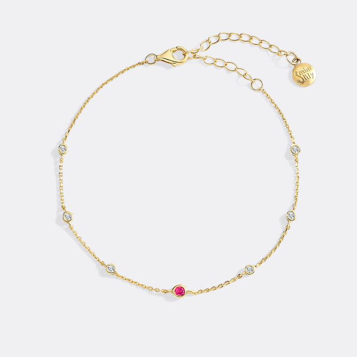Gold bracelet with small gemstones on a white background