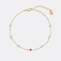 Gold bracelet with small gemstones on a white background