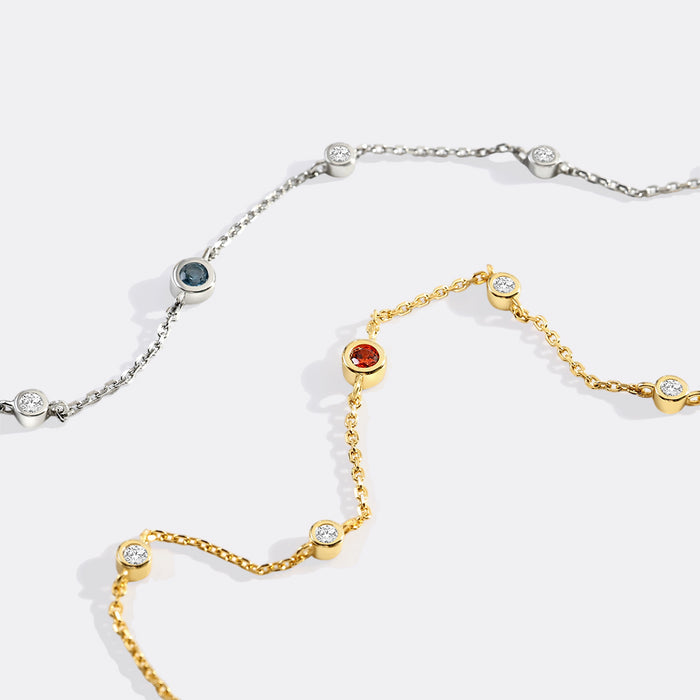 Gold and silver necklace with gemstones on a white background