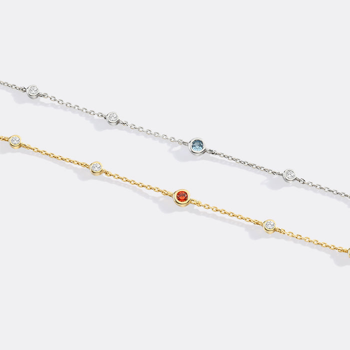 Two delicate gold and silver necklaces with gemstones on a white background