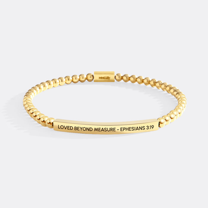 Gold bracelet with engraved text on a white background