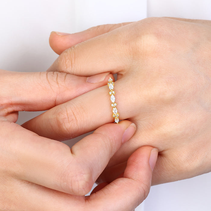Gold ring with small stones on a hand against a white background