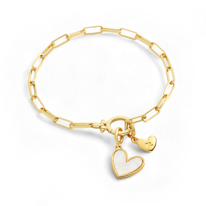 Gold bracelet with a heart-shaped charm on a black background