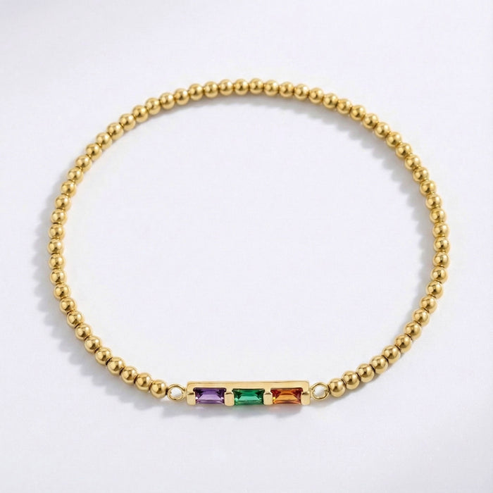 Gold bracelet with colorful gemstones on a white background