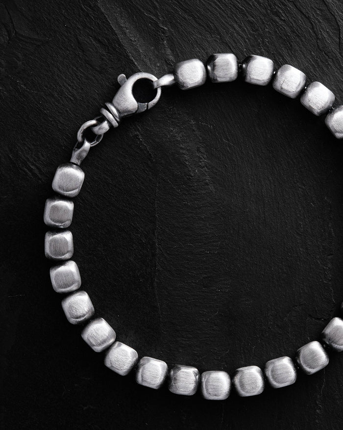 Silver beaded bracelet on a black background