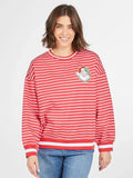 Person wearing a red and white striped sweater with a graphic design on a plain background